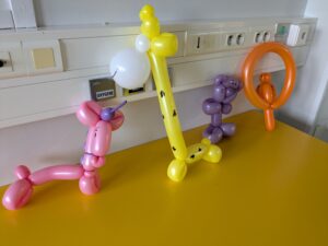 Intervention de Oscar Ballons qui transforme des ballons en oeuvre d'art (girafe, épée, singe..) pour les enfants hospitalisés